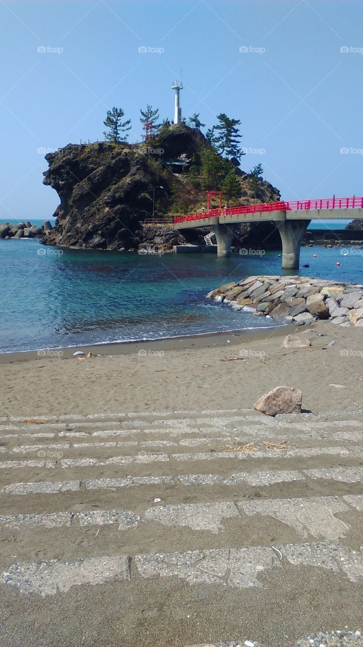 The clean sand and clear waters of the beach near the scenic landmark, Benten No Iwa.