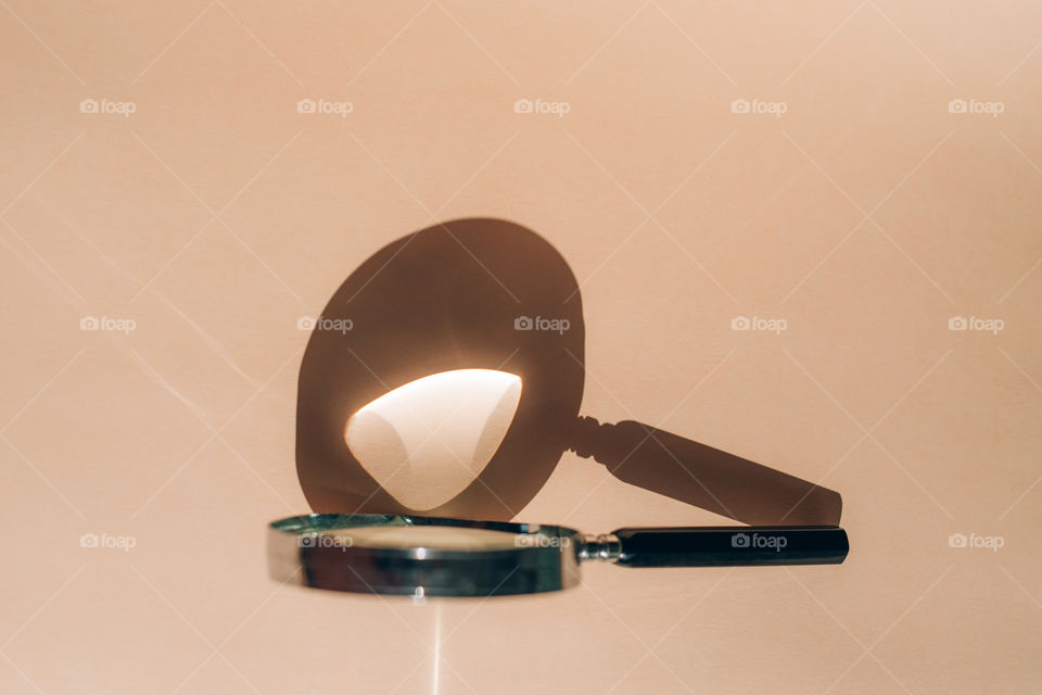Magnifying glass with the shadow and reflection of the sun