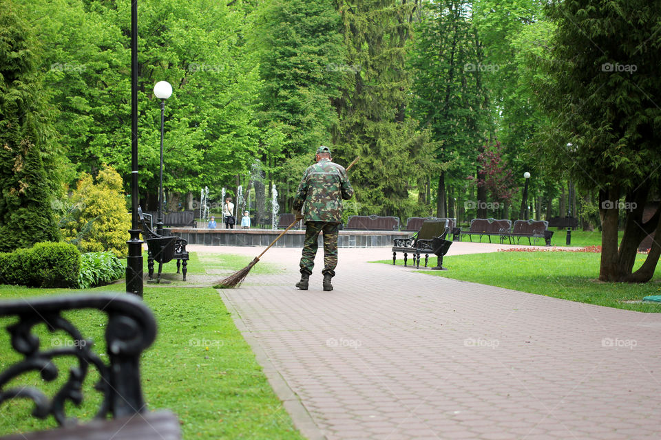 Janitor, worker, janitor sweeping the road, park, city park, nature, trees, grass, flowers