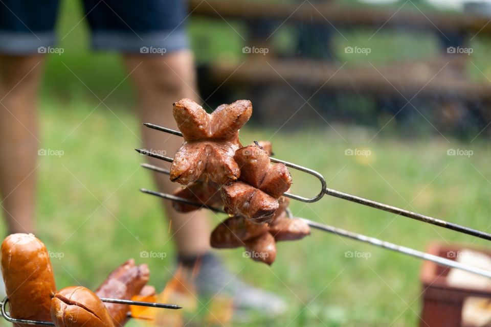cooking the sausages and meat over the fire