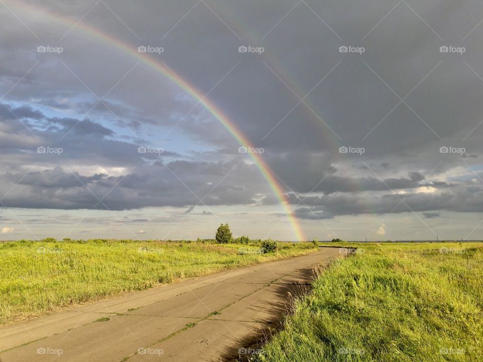 Double rainbow after a thunderstorm over a summer meadow
