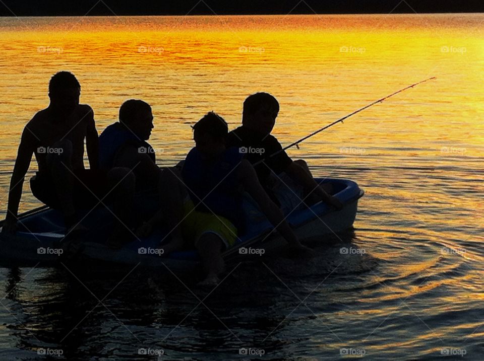 Youth boys fishing on lake at sunset. Youth boys fishing on lake at sunset