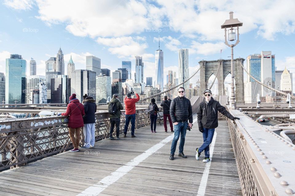 People on the Brooklyn bridge, New York City, watching the skyscrapers on Manhattan during day time 