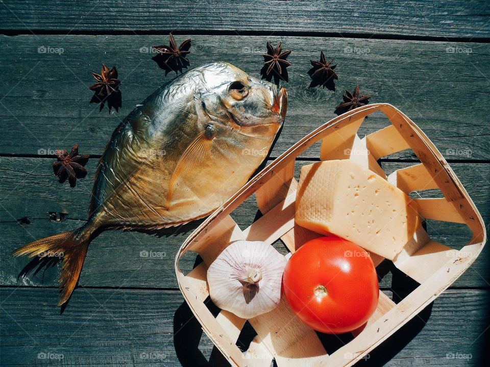 dried fish, tomato, cheese and garlic on a table