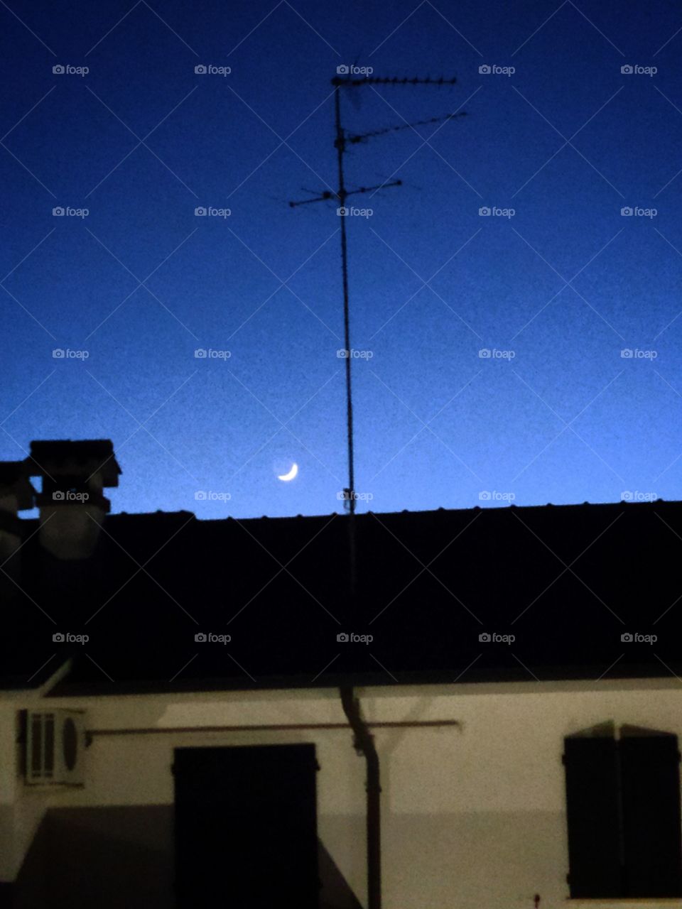 Crescent moon over the house