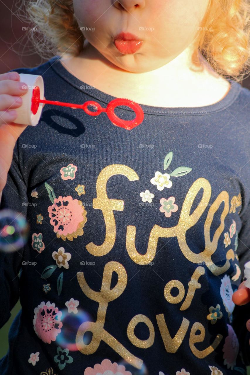 Close up of a toddler blowing bubbles