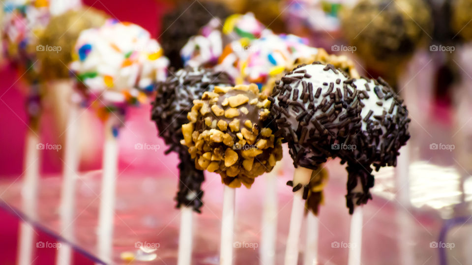 Beautiful chocolate dessert treat cake pops with colorful sprinkles and chocolate sprinkle conceptual background gourmet goodies 