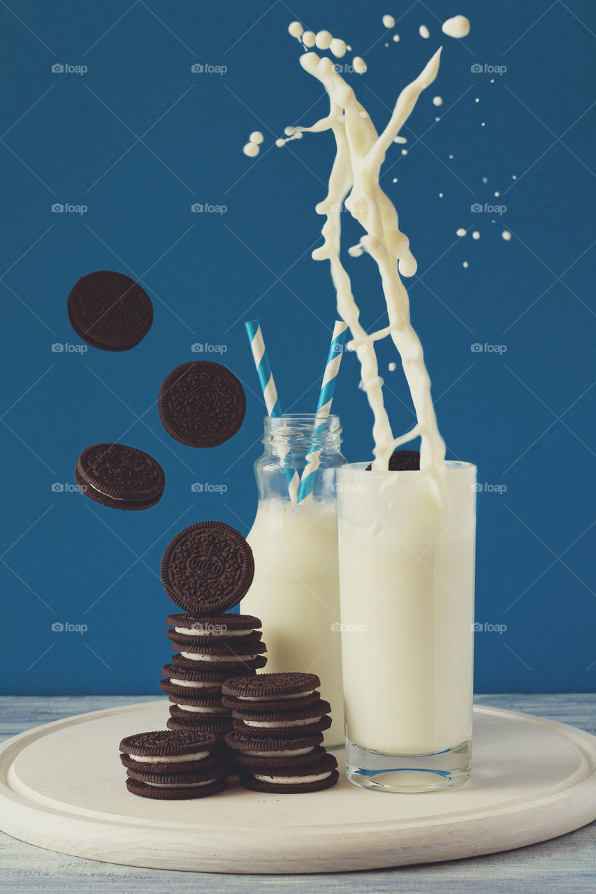 Oreo cookies and milk on blue background