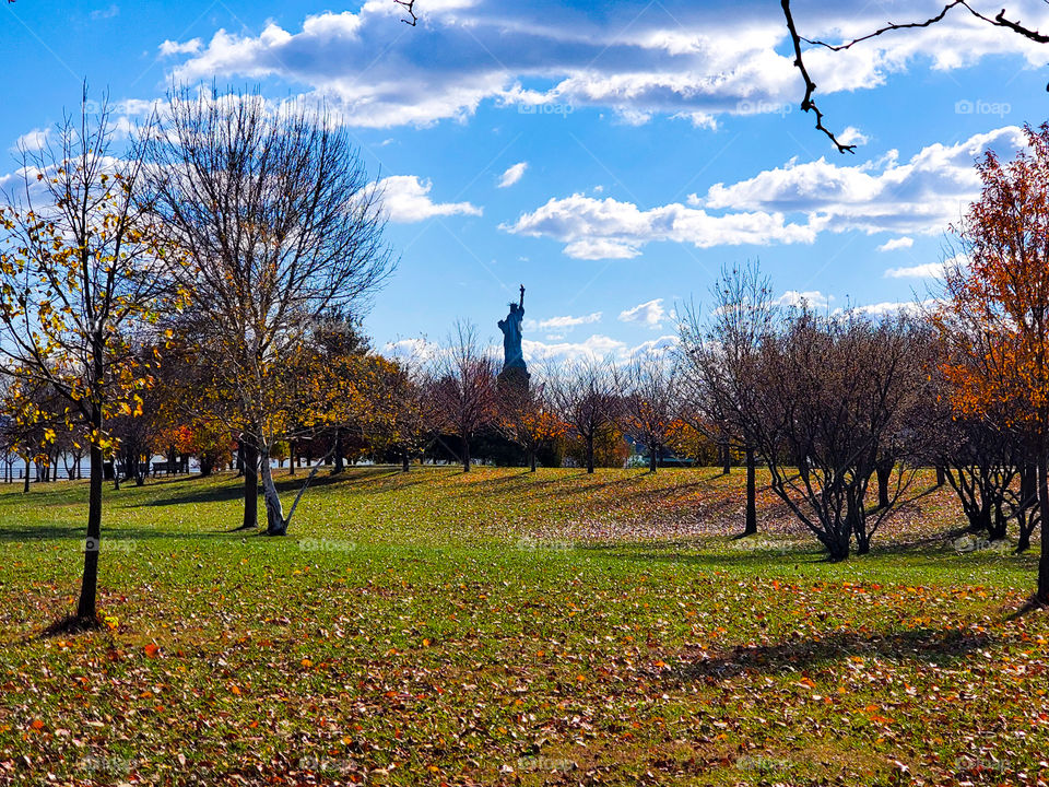 Fall colors highlight the Statue of Liberty in the distance