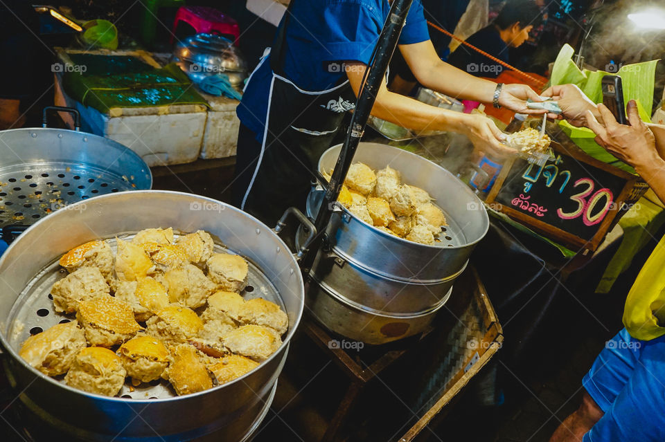 Exchange with a crab cake vendor in Thailand