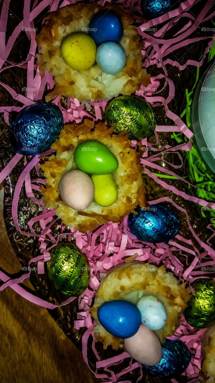 Easter candy In cookies in a basket to celebrate the holidays with paper grass, looks like a birds nest 