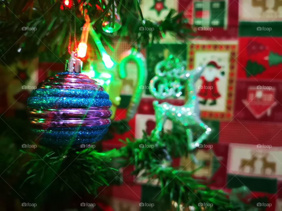 Merry Christmas! a beautiful silver deer near a little Christmas sphere in our tree, we love Christmas! traditional colors, colorful lights. green, red and blue.
now, just need a lot of presents.