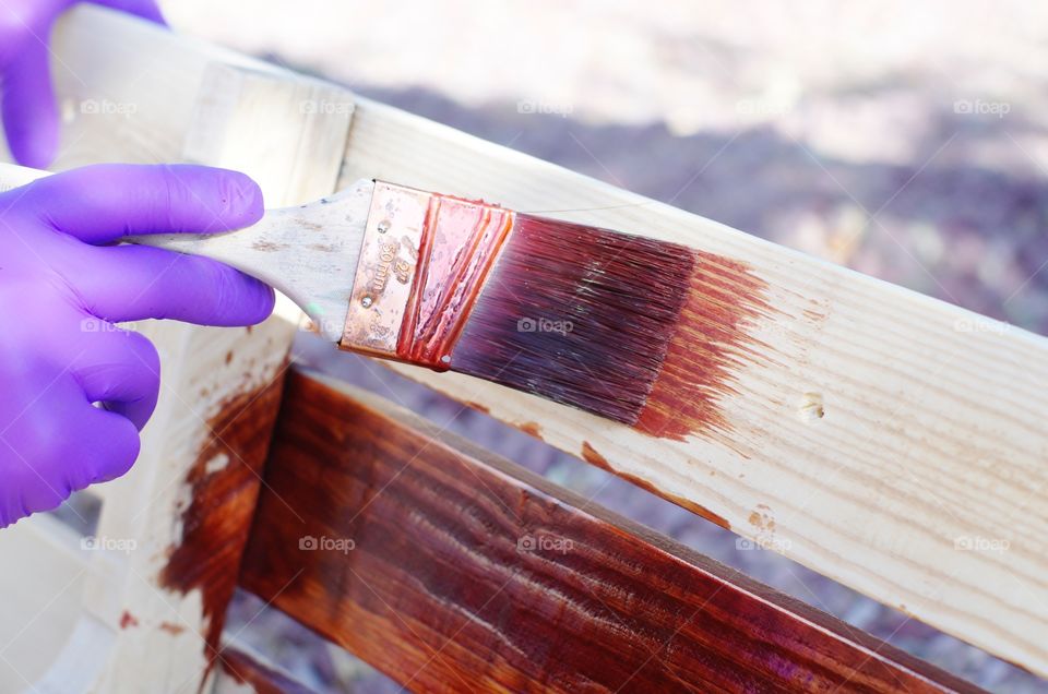 Applying wood stain to a homemade wine rack.