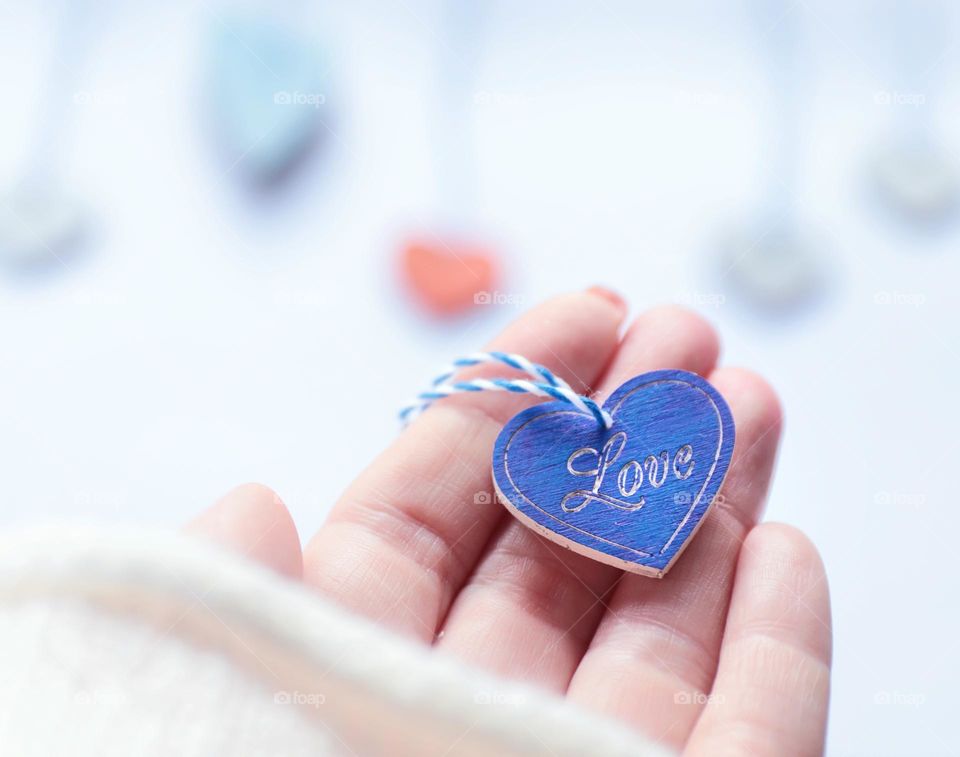 blue wooden heart with love in hand