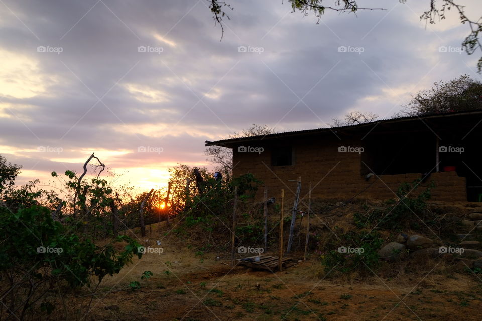 amanecer en el campo con casa, cielo azul con nubes