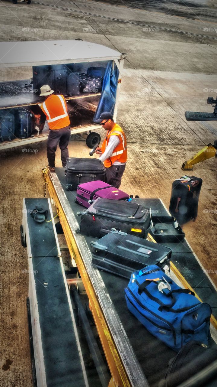 men loading luggage onto Delta plane in San Juan