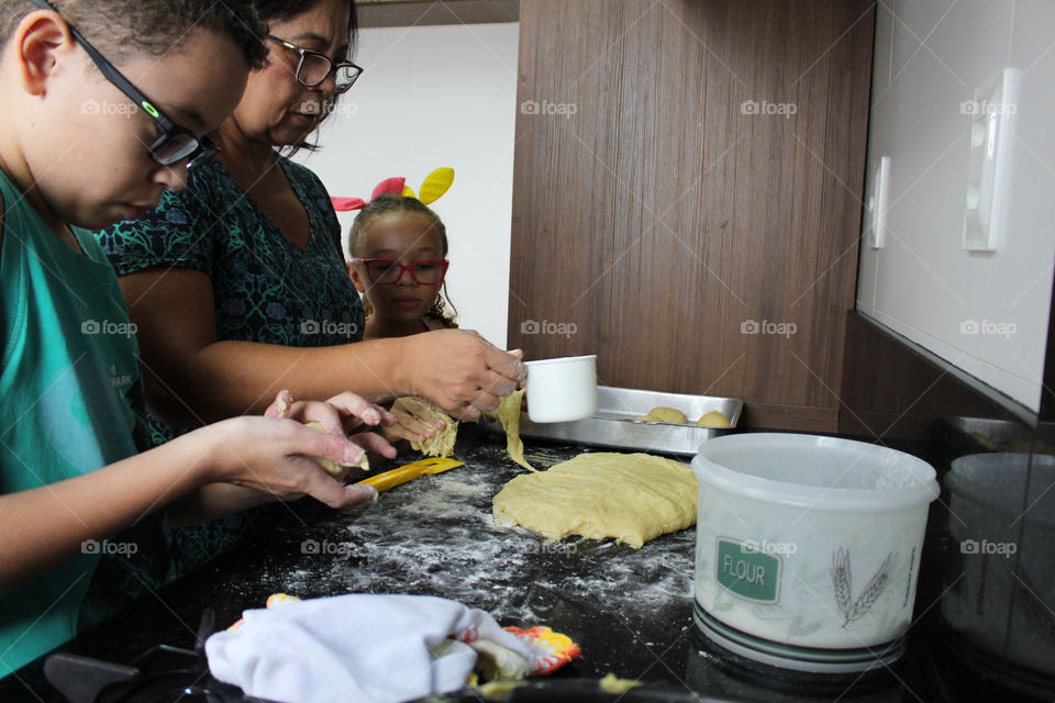 Grandmother teaching grandchildren to model bread dough