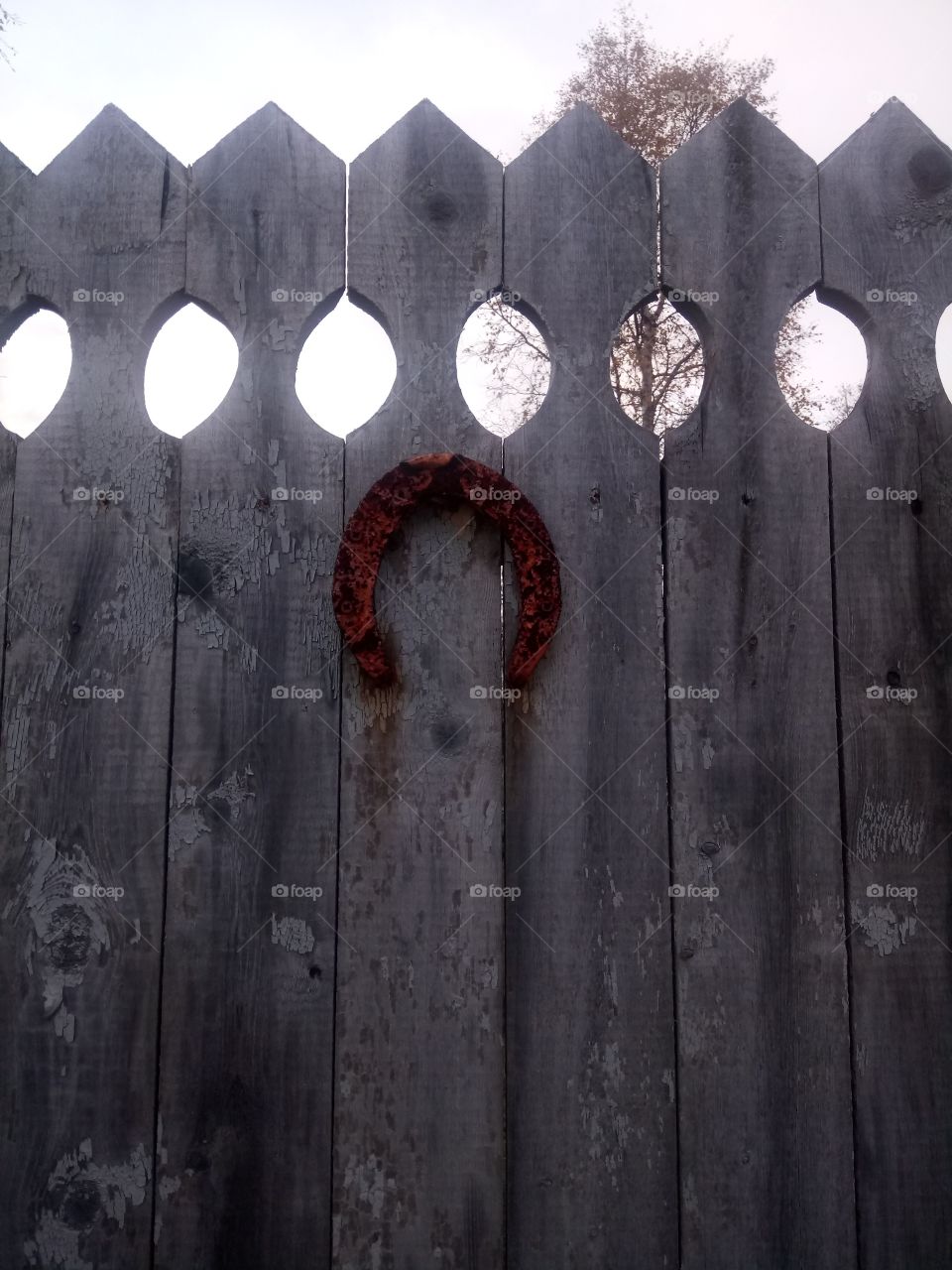 Old wooden fence with a rusty horseshoe