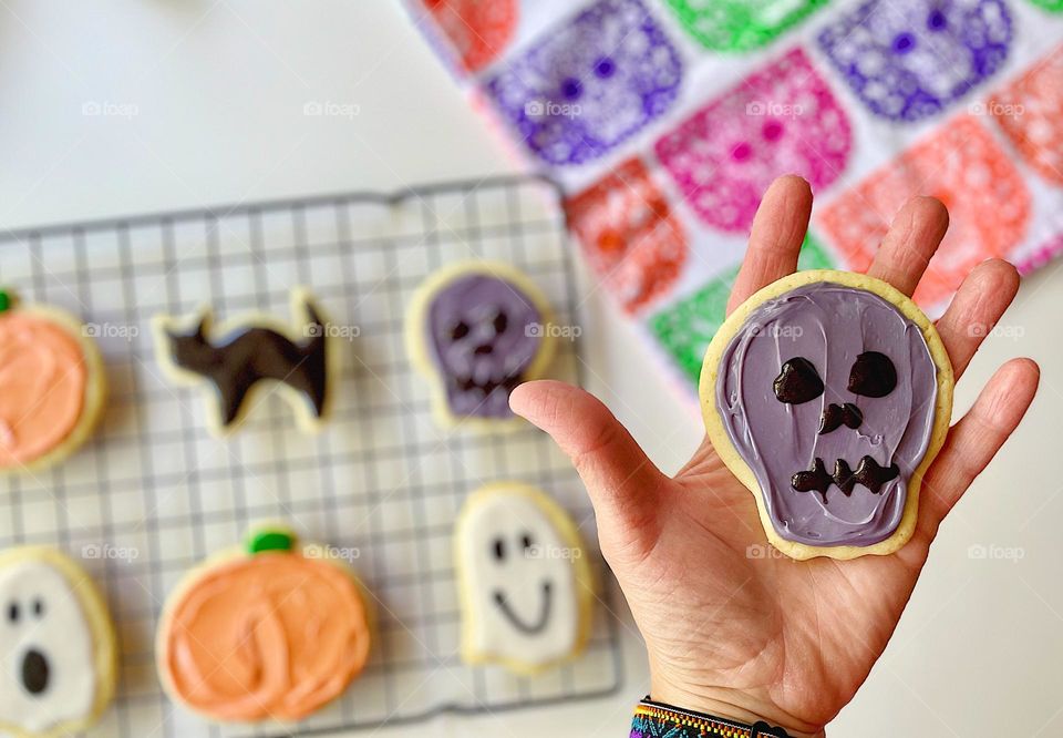 Baking sugar cookies with toddlers, making cookies with kids, baking homemade cookies, woman holds skull cookie 