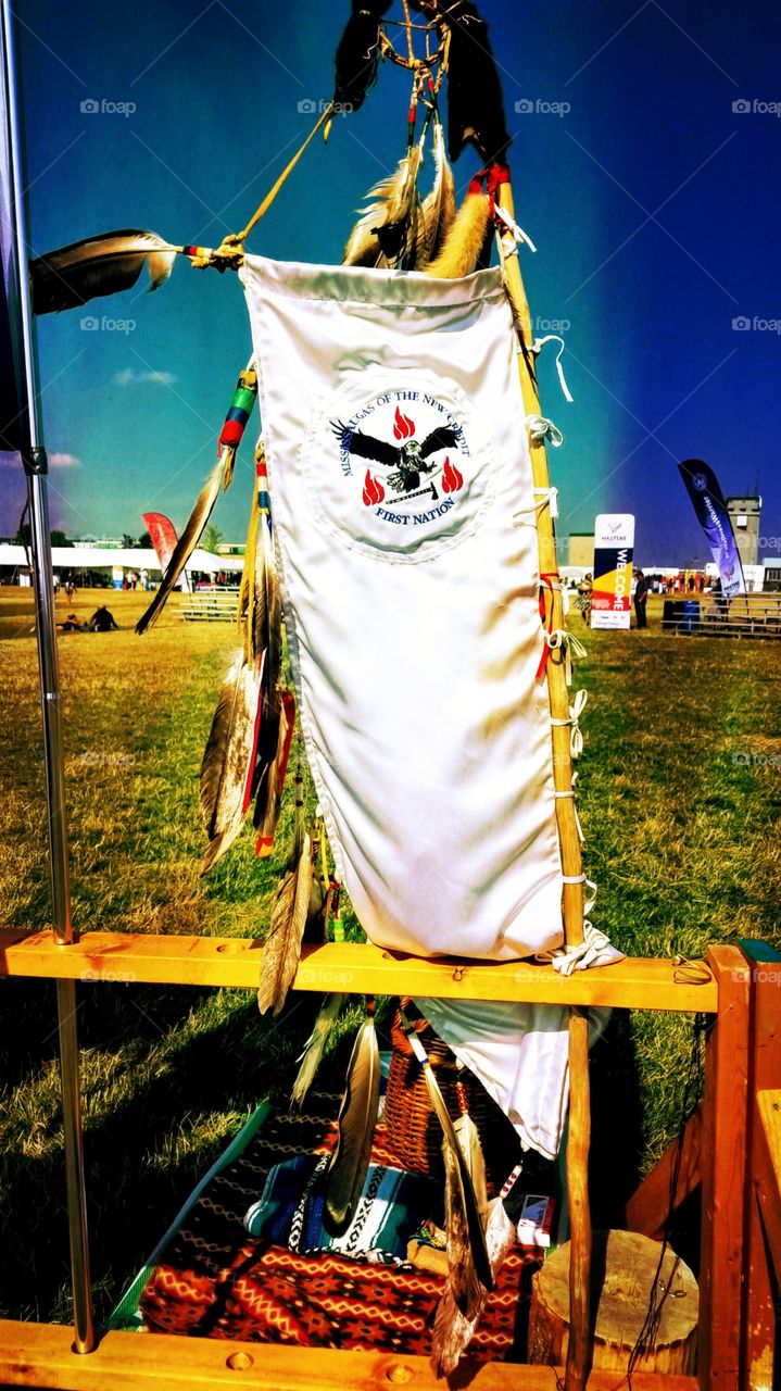 the masters of indigenous games flag sits high and mighty in the middle of the field of the pow wow.