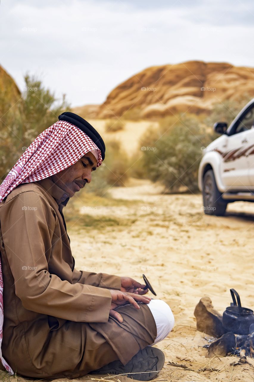 Arabian man cooking tea on stove outdoors