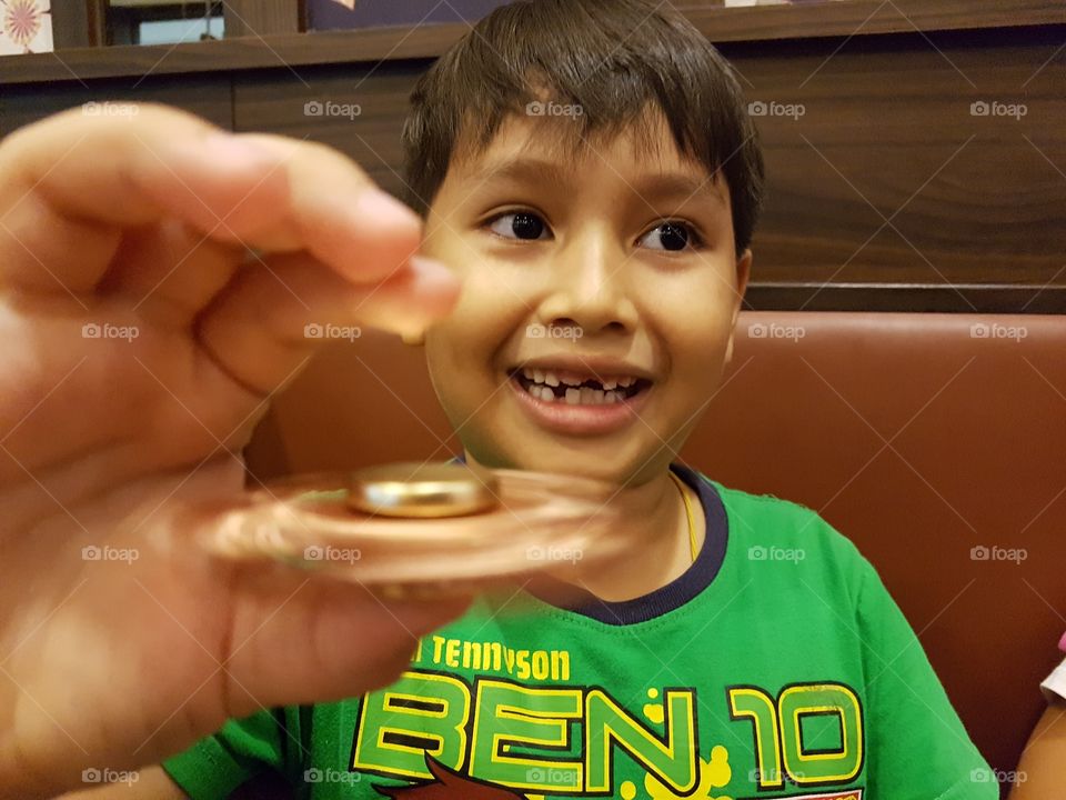 young boy playing new finger toy spinner