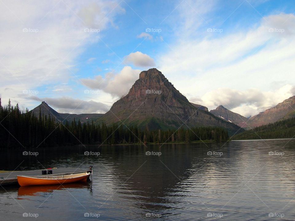 Two Medicines Lake. Orange canoe on mountain glacial lake