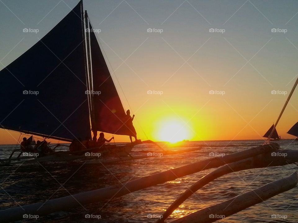 Silhouette of sailboat at beach