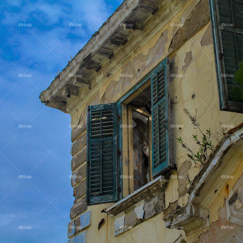 Low angle view of old damaged window