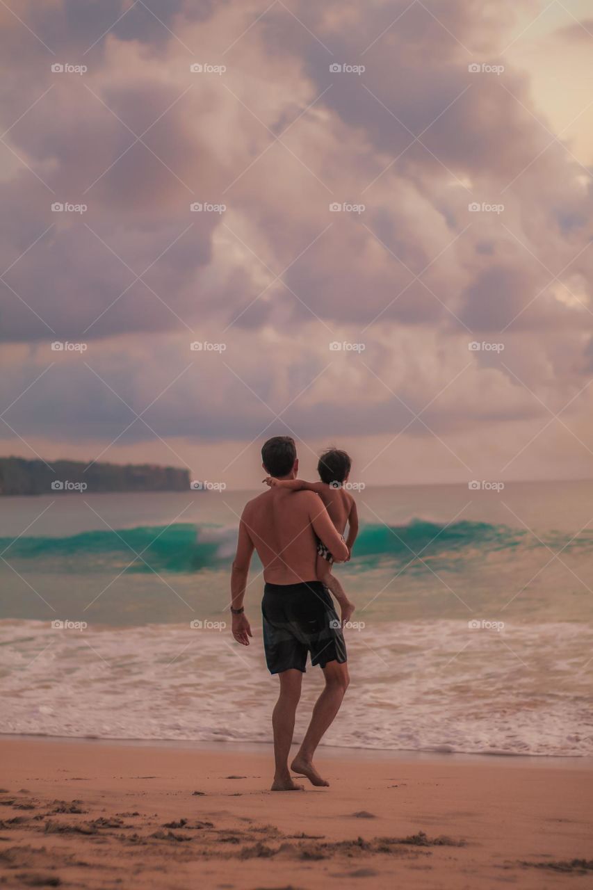 father and son enjoying the beach at sunset
