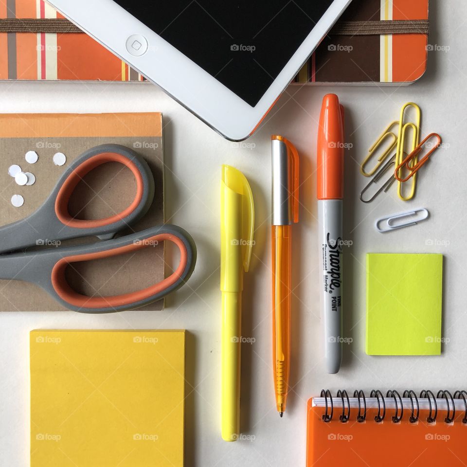 Orange and yellow themed Flatley of office supplies with technology, on a desktop