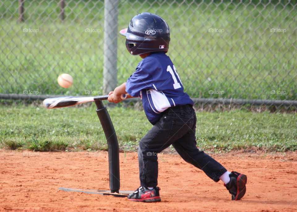 Child hitting baseball off tee