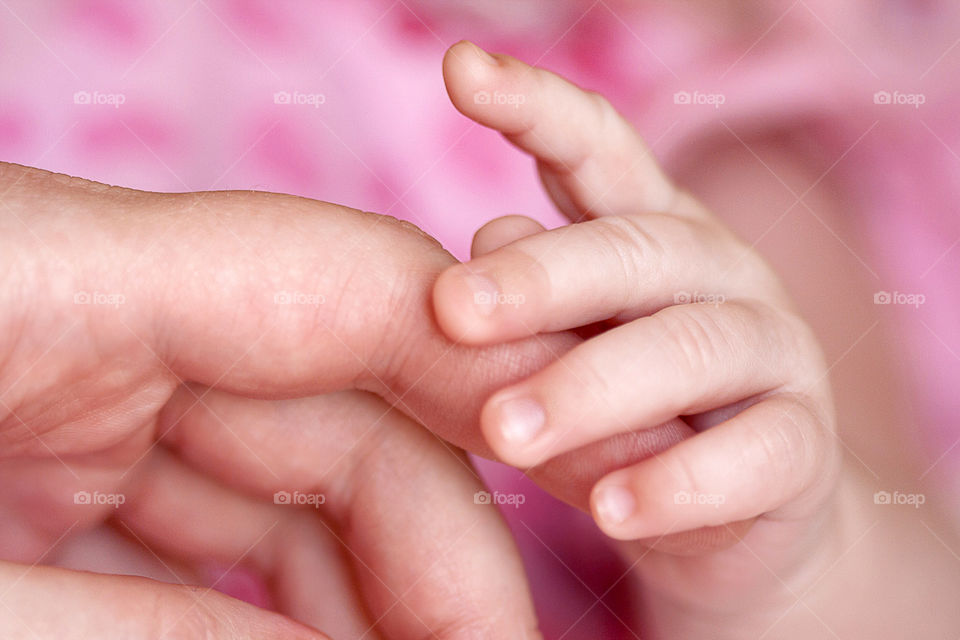Hands of mother and a child. Close up.