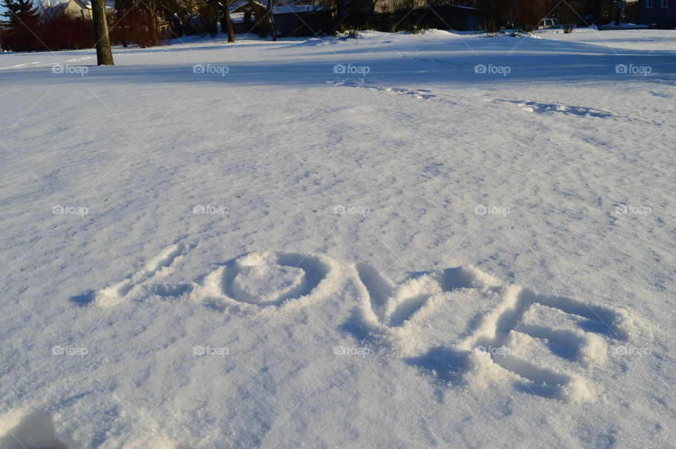 Love word carved on snowy landscape