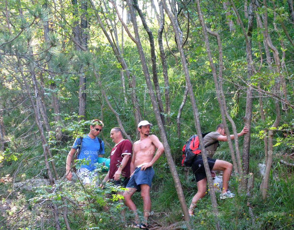 Young backpackers looking for the water holes directions into the bush of Palar, Friuli region, Italy