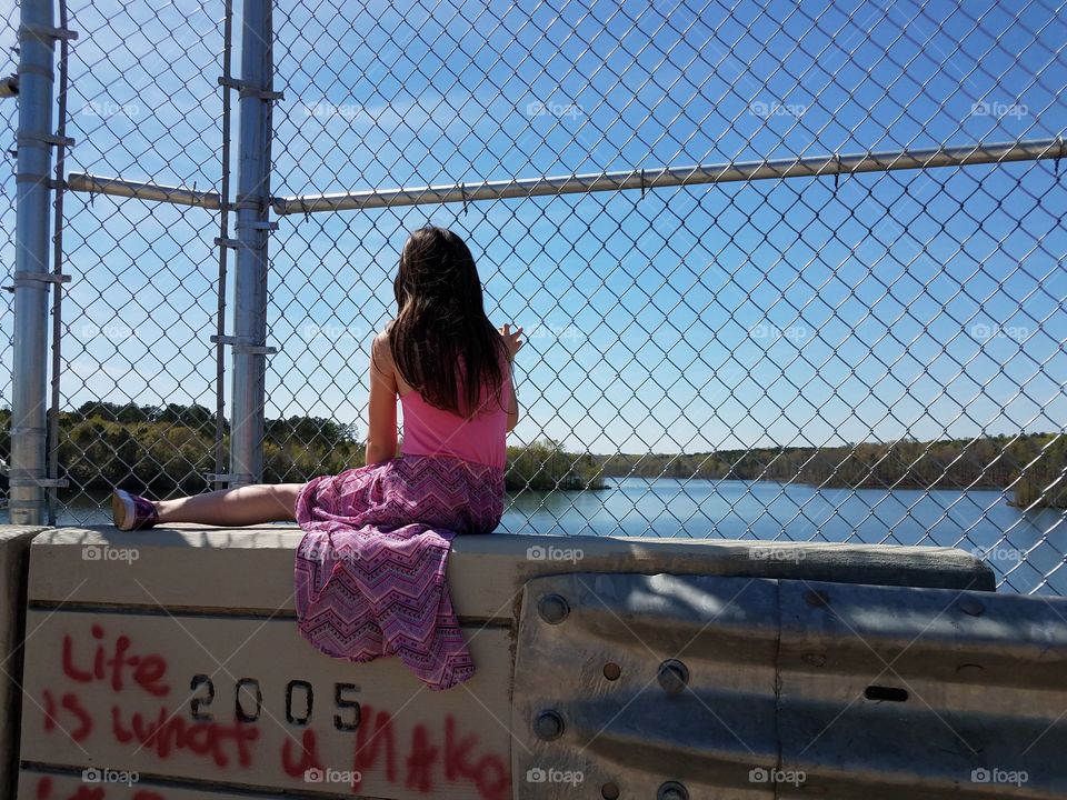 Girl sitting on bridge