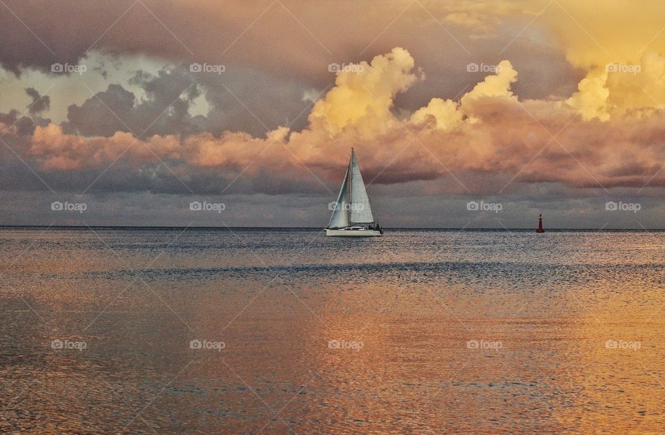 dramatic sky sunset and white sail boat at the baltic sea coast in poland