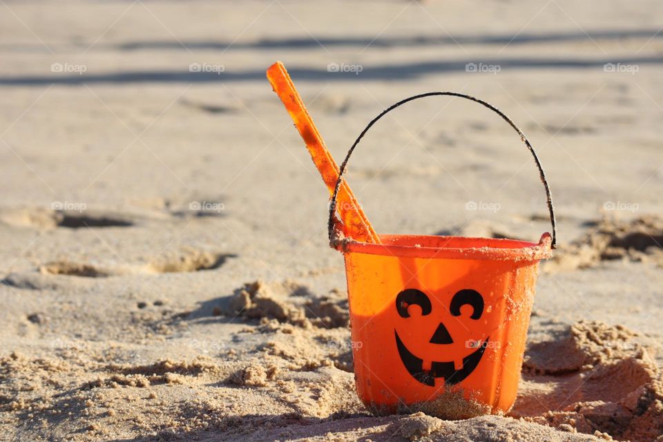 Trick or treat bucket smiling on the beach 