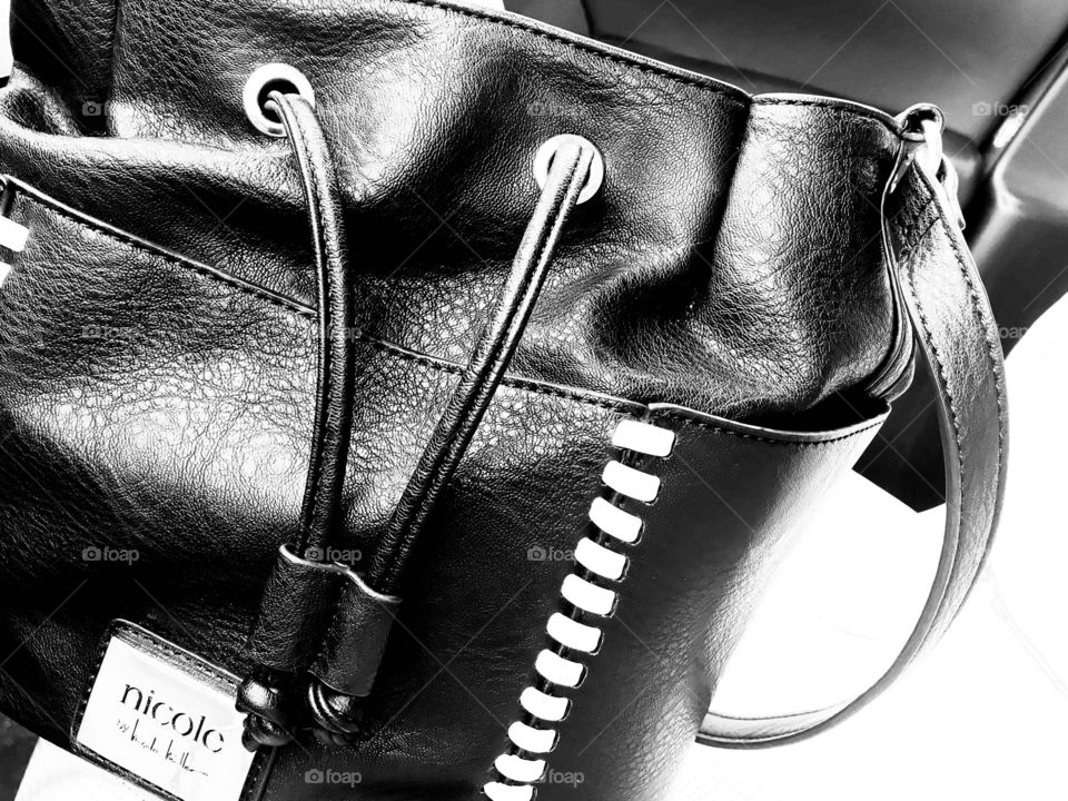 Black and white photo of leather purse with white stripes on side is a fun every day picture. 