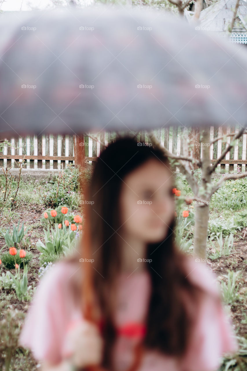 Girl with umbrella blurred in foreground.