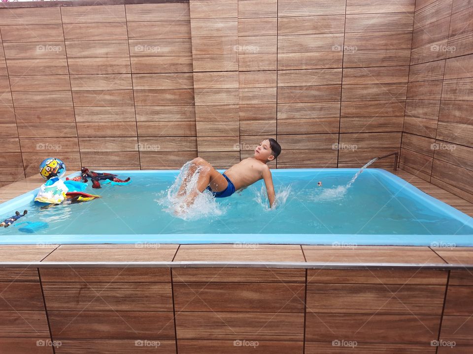 child jumping in the pool cooling off