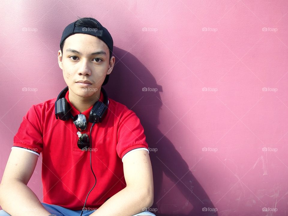 young teenage boy with cap, backpack, sunglasses and earphones