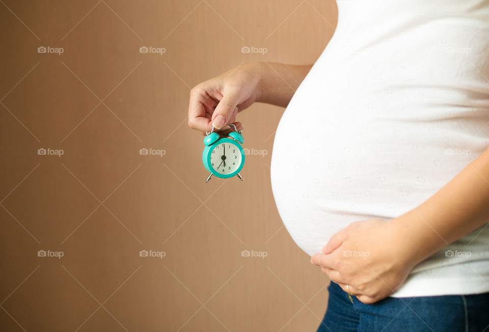 Pregnant women holding clock