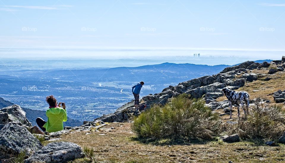 People enjoying the view of Madrid from the top of a hill 