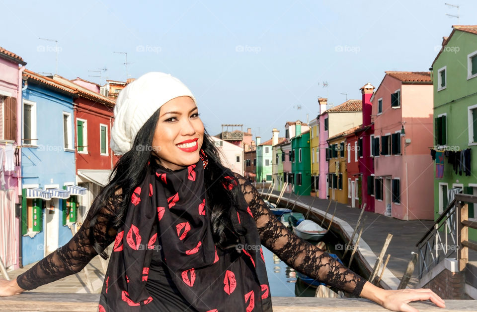 A young woman standing on bridge of canal