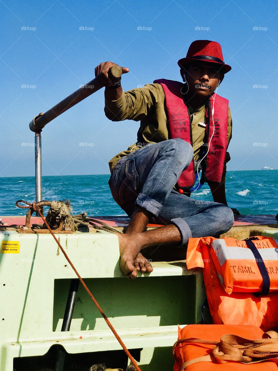 A teenage sailor with lifeguard trying to move from one place to another place for his destination. A beautiful click ! 