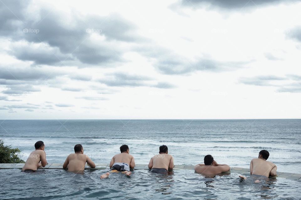 swimming in a swimming pool by the paratritis beach with friends while on vacation during the day when the weather is sunny, the hot beach breeze feels fresh when in the pool