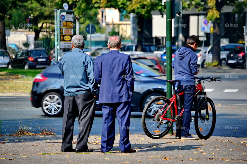 two older men standing chatting in the street
