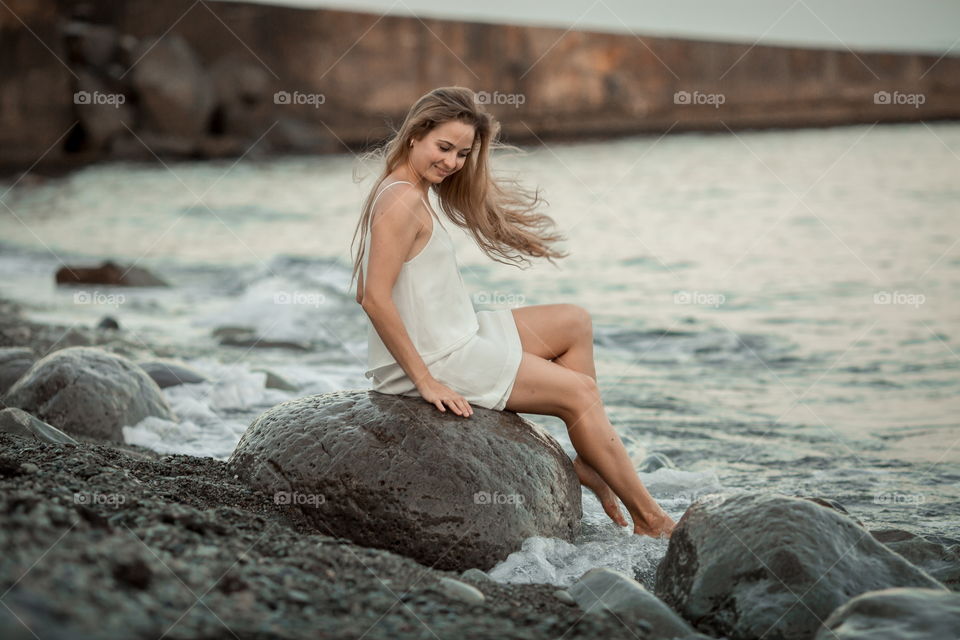 Beautiful young woman on sea coast 