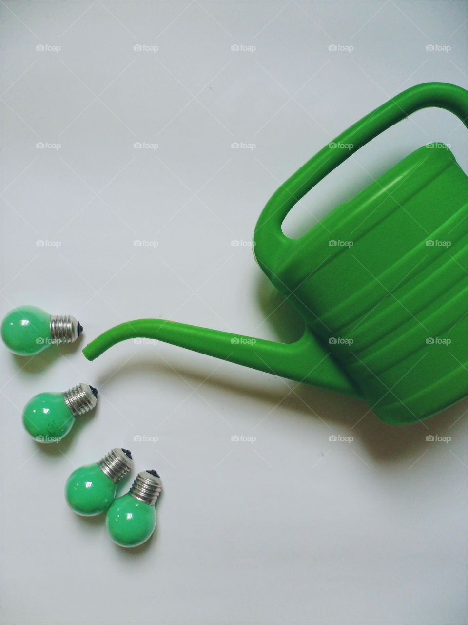 Green light bulbs and a green watering can for watering flowers